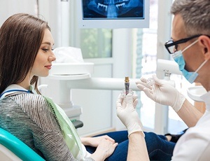 dentist demonstrating how dental implants work to a patient
