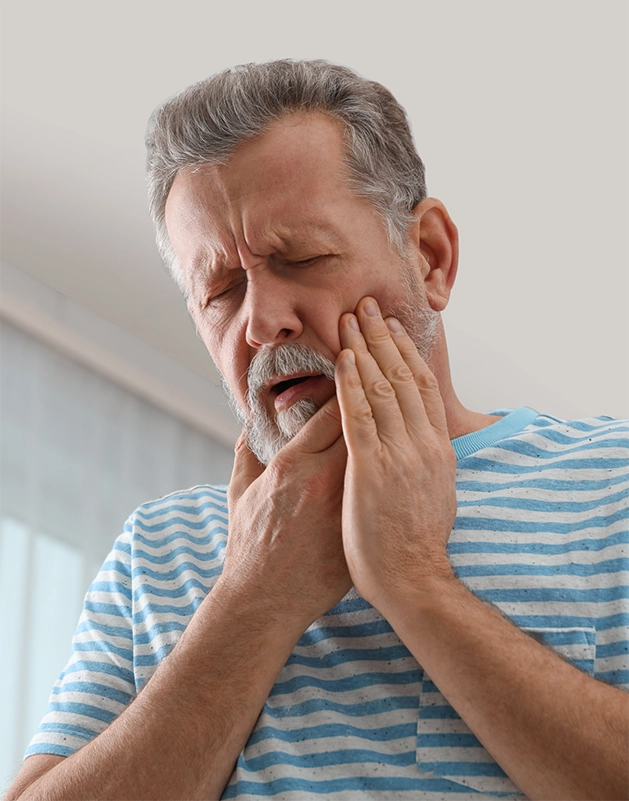 Senior man holding his cheek in pain