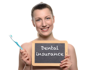 Smiling woman holding dental insurance sign