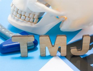 wooden letters that spell TMJ next to a plastic skull