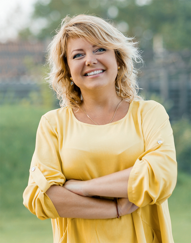 Blonde woman smiling in a yellow blouse