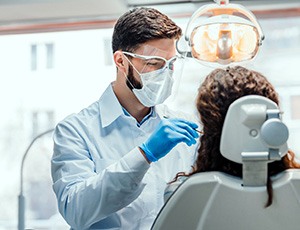 A dentist performing gum disease treatment on a woman