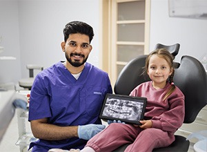 Child and dentist posing with dental X-ray