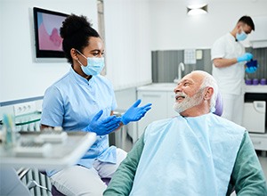 Senior patient speaking with dental team member