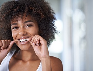 closeup of woman flossing her teeth 