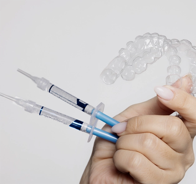 Hand holding a take-home teeth whitening kit