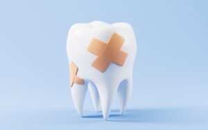 A large model tooth with several bandaids on it in front of a light blue background